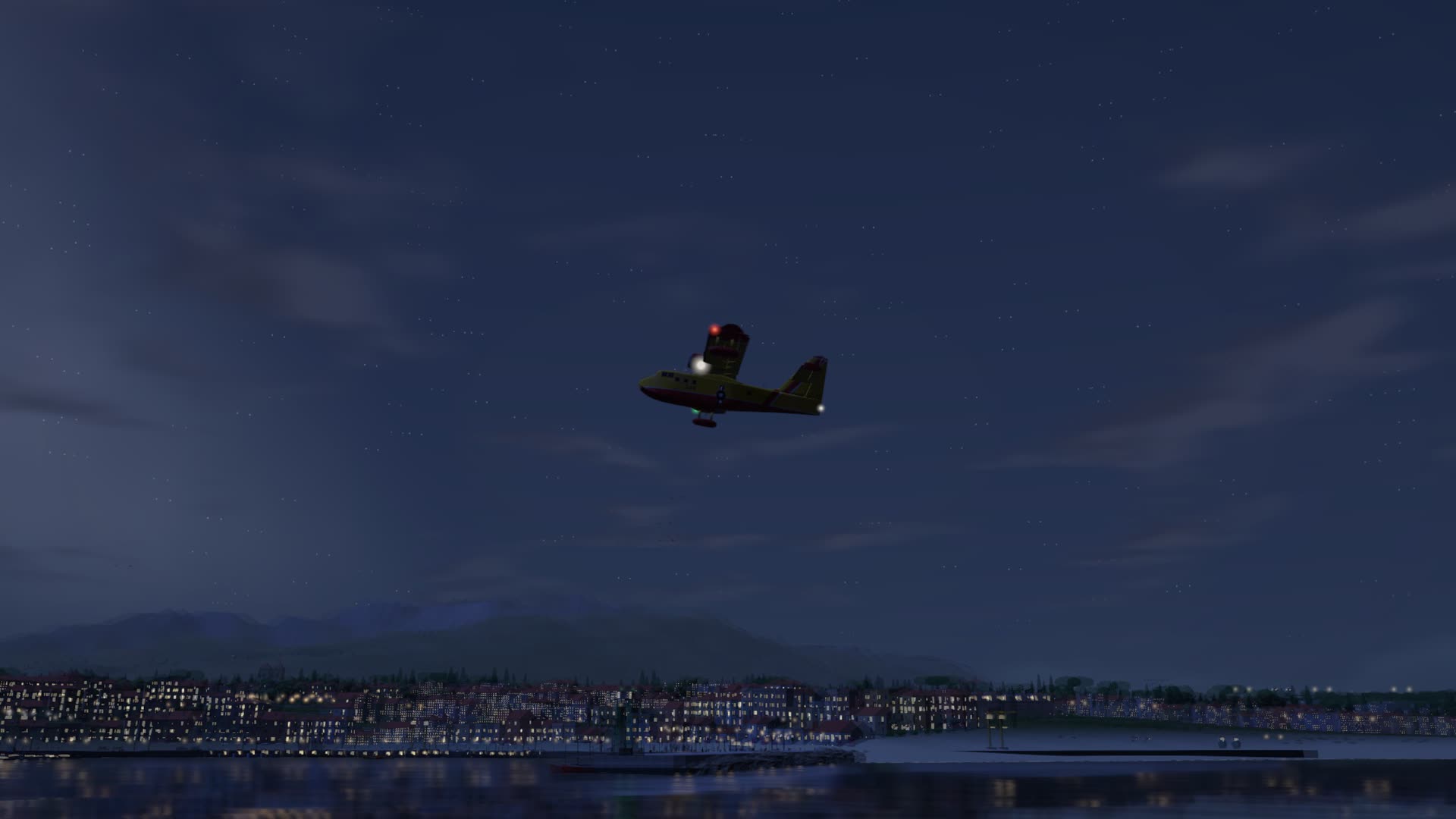 At night over the harbour, the town’s lights along the water.